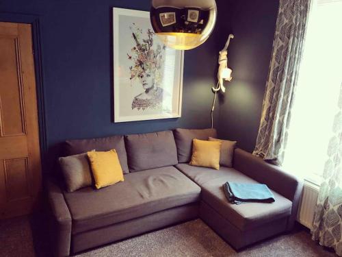 a living room with a couch with yellow pillows at Handbridge in Chester sleeps 7 with BT Sports & Pac-man in Hough Green
