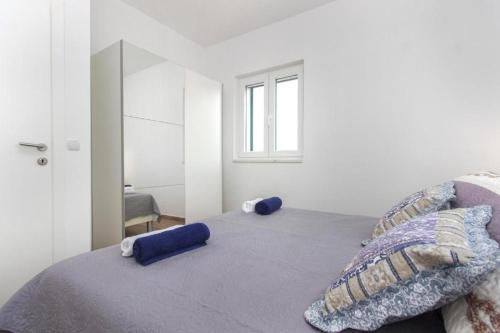 a bedroom with a bed with blue pillows and a window at Riva 2 in Krapanj