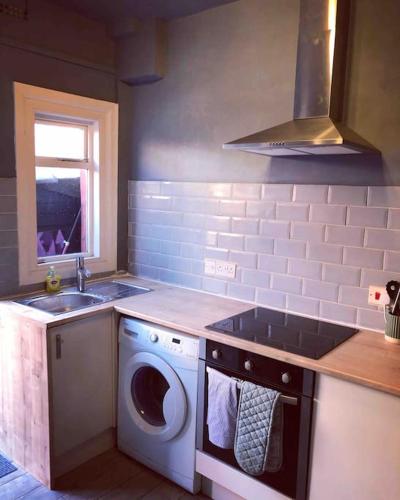 a kitchen with a washing machine and a sink at Chester/Handbridge sleeps 6 with BT Sports & Pac-man in Hough Green