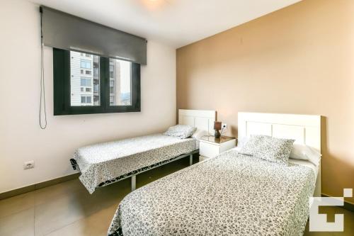 1 Schlafzimmer mit 2 Betten und einem Fenster in der Unterkunft Apartamento Bernia al Mar 8B - Grupo Turis in Calpe