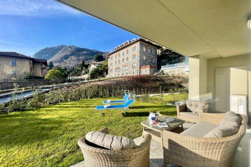 une terrasse avec vue sur une pelouse avec des chaises dans l'établissement Condominio Modern House, à Menaggio