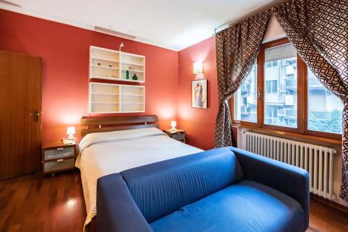 a bedroom with a bed and a blue couch at Mestre da Luca Apartment con posto auto! in Mestre