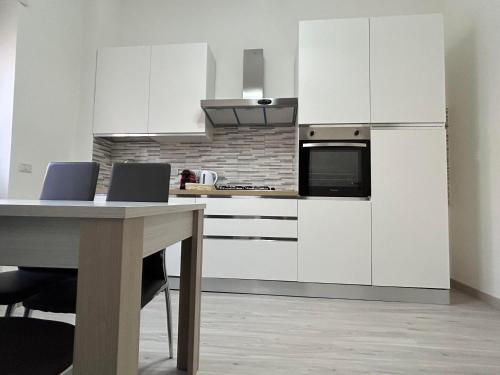 a kitchen with white cabinets and a table with chairs at Palmira's Rome Sweet Home in Rome