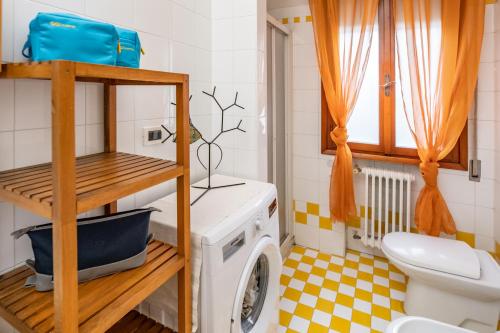 a bathroom with a washing machine and a toilet at Mestre da Luca Apartment con posto auto! in Mestre