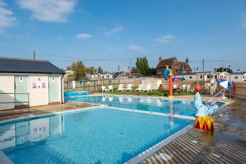 a large swimming pool with a inflatableentityituresigunigunigunigunigunigun at Vista Caravan Hire in Seasalter