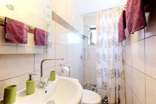 a white bathroom with a sink and a toilet at Pension Merbald in Beilngries