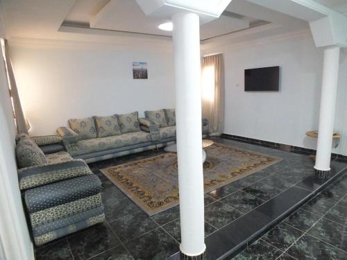 a living room with a couch and a tv at Hotel El Medina in Nouadhibou
