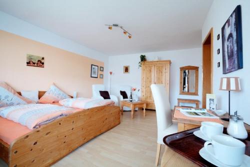 a bedroom with a bed and a living room at Pension Merbald in Beilngries