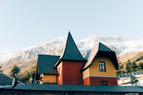 a church with snow covered mountains in the background at La Villetta Food & Drink Rooms for Rent - No Reception - in LʼAquila