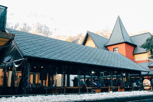 a train station with a building in the snow at La Villetta Food & Drink Rooms for Rent - No Reception - in LʼAquila