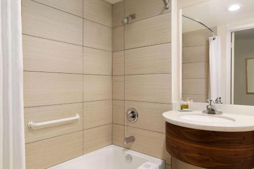 a bathroom with a sink and a shower at Days Inn by Wyndham Victoria Airport Sidney in Sidney