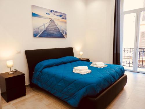 - une chambre avec un lit et une couette bleue dans l'établissement Napoli Centrale Suite, à Naples