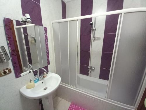 a bathroom with a sink and a shower with a mirror at Stunning Sea View Flat (One Bed Room)Entire Place in Alexandria