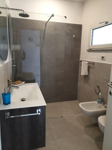 a bathroom with a shower and a sink and a toilet at Simon's Place Lake View in Nesso