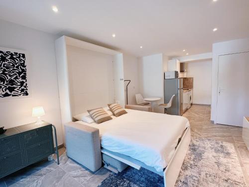 une chambre blanche avec un lit et une cuisine dans l'établissement Studio moderne dans le golfe de Saint-Tropez, à Gassin