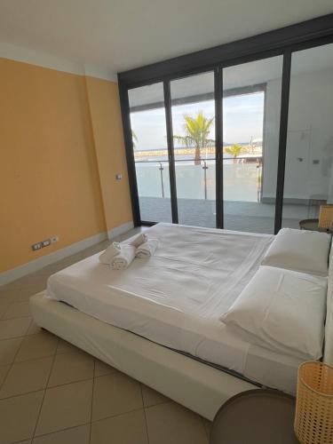 a bedroom with a large bed with a view of the ocean at San Lorenzo Marina Apartment in San Lorenzo al Mare