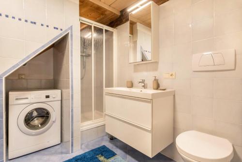 a bathroom with a washing machine and a washer and dryer at Moserhof Ferienwohnung Schartblick in Sarntal