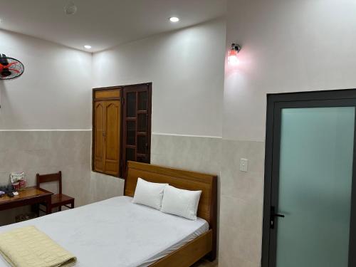a bedroom with a bed and a table and a window at Hoàng Linh Hotel in Buon Ma Thuot