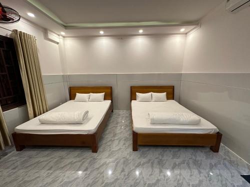 two beds in a small room withthritisthritis at Hoàng Linh Hotel in Buon Ma Thuot