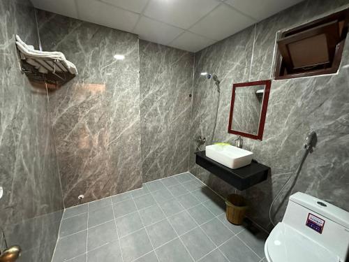 a bathroom with a toilet and a sink in it at Hoàng Linh Hotel in Buon Ma Thuot