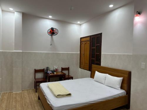 a bedroom with a bed and a table and a clock at Hoàng Linh Hotel in Buon Ma Thuot