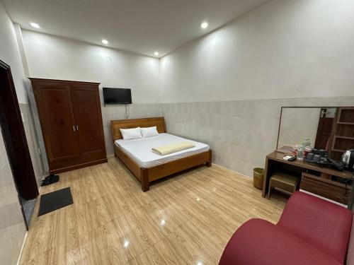a bedroom with a bed and a mirror and a chair at Hoàng Linh Hotel in Buon Ma Thuot