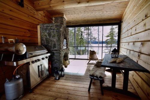 eine Küche mit einem Herd und einem Tisch in einer Hütte in der Unterkunft Villa Northern Lights by DG Lomailu, Lapland, Finland in Kyrö