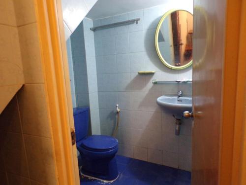 a bathroom with a blue toilet and a sink at Dimocrata in Phnom Penh