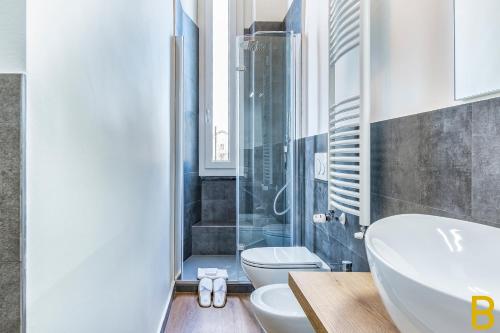 La salle de bains est pourvue d'un lavabo, de toilettes et d'une douche. dans l'établissement BePlace Apartments in Fiera, à Milan
