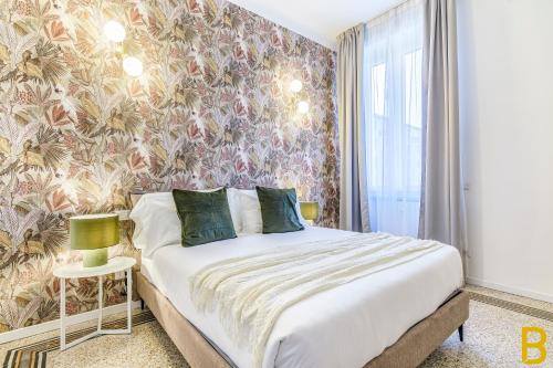 - une chambre avec un lit et un papier peint floral dans l'établissement BePlace Apartments in Fiera, à Milan