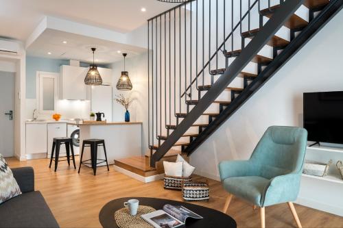 uma sala de estar com uma escada, um sofá e uma mesa em Lola 14 Suite Apartment em Sevilha