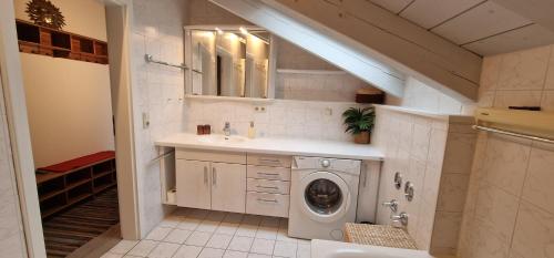 a bathroom with a washing machine and a sink at ciao-aschau FeWo Bergsonne Kurtenbach in Aschau