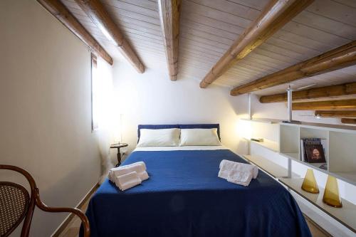 a bedroom with a blue bed in a room with wooden ceilings at Penthouse Luxury Quattro Canti in Palermo