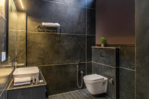 a bathroom with a toilet and a sink and a shower at The BlackPearl Hillcrest in Kasauli