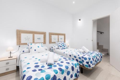 2 camas con sábanas azules y blancas en un dormitorio en Home2Book Charming Piedra Playa, Terrace, en Cotillo