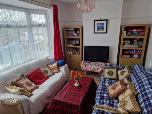 a living room with two couches and a tv at Bob's House quiet retreat with large shared garden in Loughborough