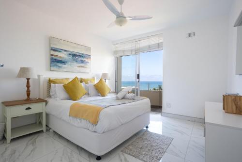 a bedroom with a bed with a view of the ocean at 24 Sea Lodge - Sea Viewing Apartment in Durban