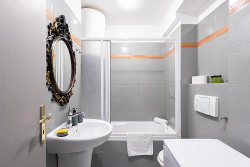 a white bathroom with a sink and a mirror at Crystal Apartment in Prague