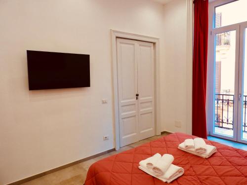 una camera con letto, TV e finestra di Napoli Centrale Suite a Napoli