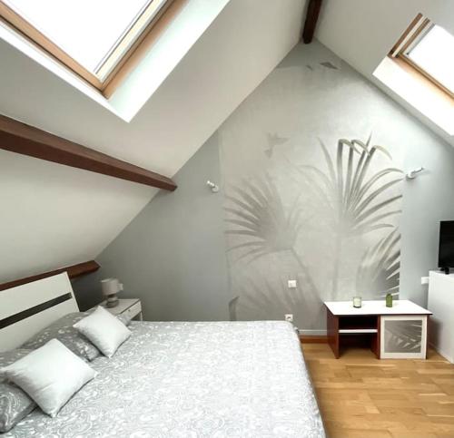 - une chambre avec un lit et un mur avec des fenêtres dans l'établissement Duplex tout confort dans Boulogne, à Boulogne-sur-Mer