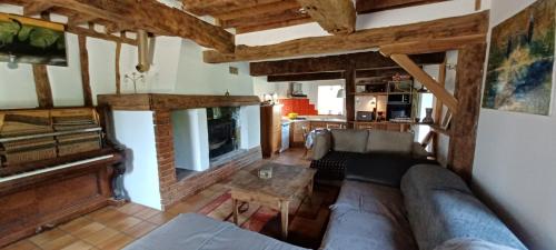 ein Wohnzimmer mit einem Sofa und einem Tisch in der Unterkunft Maison dans le sud du Gers 