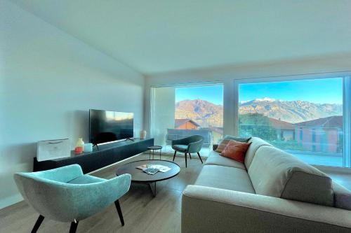 un salon avec un canapé et des chaises et une grande fenêtre dans l'établissement Condominio Modern House, à Menaggio