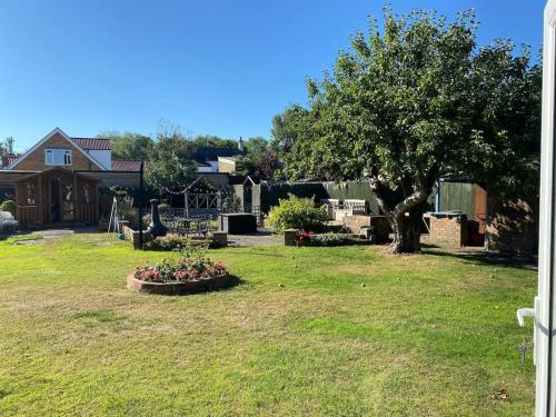 a yard with a tree and a house at The Old Nurseries Luxury Guest Suite in Lincolnshire