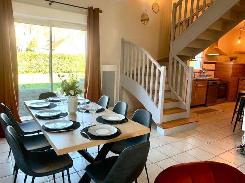 une salle à manger avec une table et des chaises et un escalier dans l'établissement Havre de paix spa proche Amboise & châteaux de la Loire, à Noizay