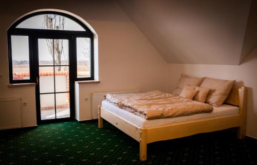a bed in a room with a large window at Hájenka Kozmice in Kozmice