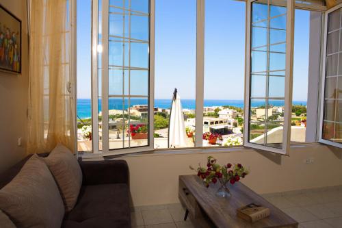 - un salon avec un canapé, une table et des fenêtres dans l'établissement Theodore Seaview Home, à Sfakaki