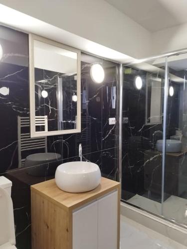 a bathroom with a white sink and a mirror at A G Studio's Palas-Iasi in Iaşi