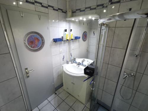 a white bathroom with a sink and a shower at FeWo Albrecht direkt am Diemelsteig in Diemelsee