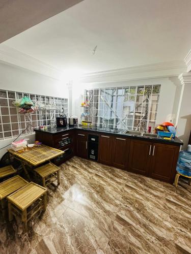 a kitchen with wooden tables in a room at Nam Anh Homestay in Bao Loc