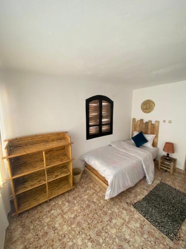 a bedroom with a bed and a wooden dresser at Sable beach surf camp taghazout in Taghazout